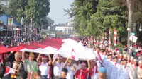 Ratusan warga Bogor mengarak bendera merah putih raksasa.