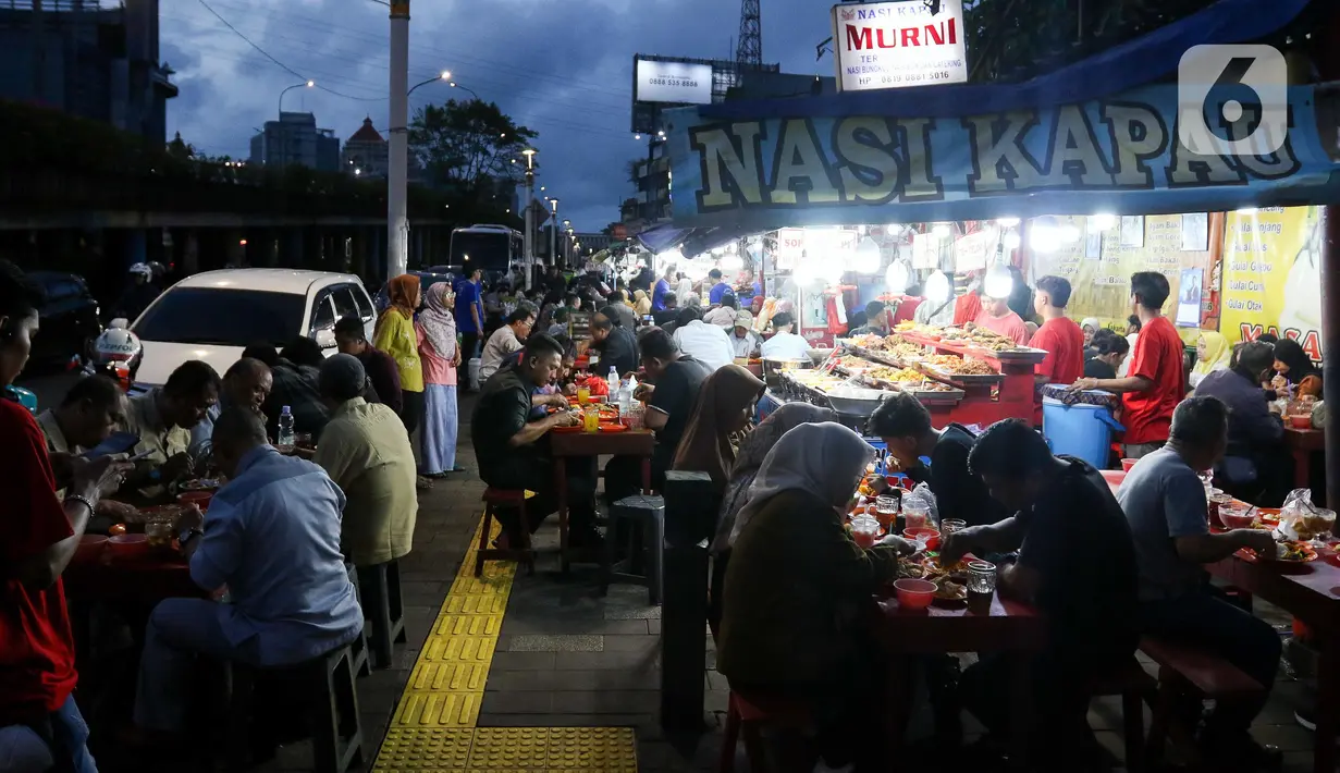 Warga menikmati waktu serta menu berbuka puasa di Sentra Kuliner Nasi Kapau di Jalan Kramat Raya, Senen, Jakarta, Senin (17/3/2025). (Liputan6.com/Herman Zakharia)