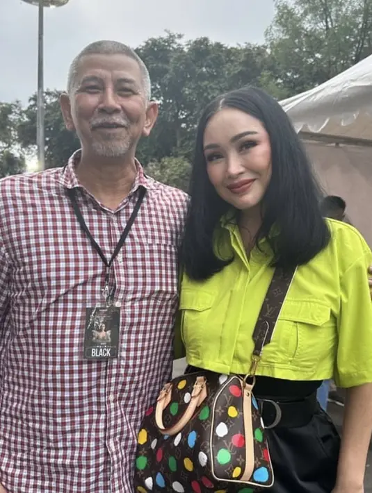 Titi DJ tampil dengan atasan crop top warna neon, dipadu celana hitam. (@ti2dj)