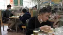Pengunjung saat makan siang ditutupi panel plastik transparan untuk mengisolasi satu sama lain guna mencegah penyebaran virus corona di Hong Kong, Rabu, (12/2/2020). WHO kini menyebut virus tersebut dengan nama Covid-19, yang merupakan singkatan dari penyakit coronavirus 2019. (AP Photo/Kin Cheung)