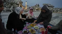 Anggota keluarga Al-Najar berbuka puasa selama bulan suci Ramadan di tengah reruntuhan bangunan yang hancur di Kota Gaza, Jumat 13 Maret 2026. Di tengah puing-puing bangunan yang nyaris rata dengan tanah, masyarakat Gaza tetap menjaga nuansa hangat kebersamaan Ramadan seperti biasanya. (AP Photo/Jehad Alshrafi)