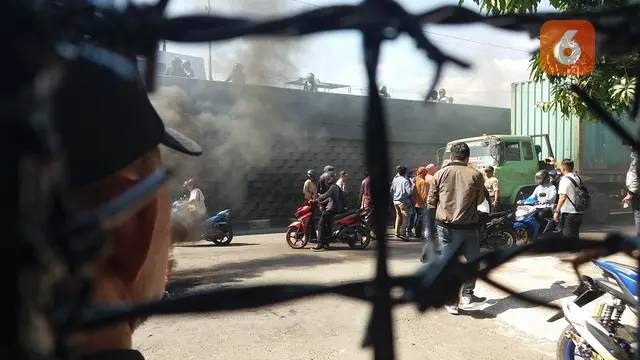 Mahasiswa mengadang mobil truk yang melintas di depan Kantor Kejati Sulsel saat berunjuk rasa menuntut penuntasan kasus dugaan suap proyek DAK senilai Rp49 miliar untuk Kabupaten Bulukumba (Liputan6.com/ Eka Hakim)