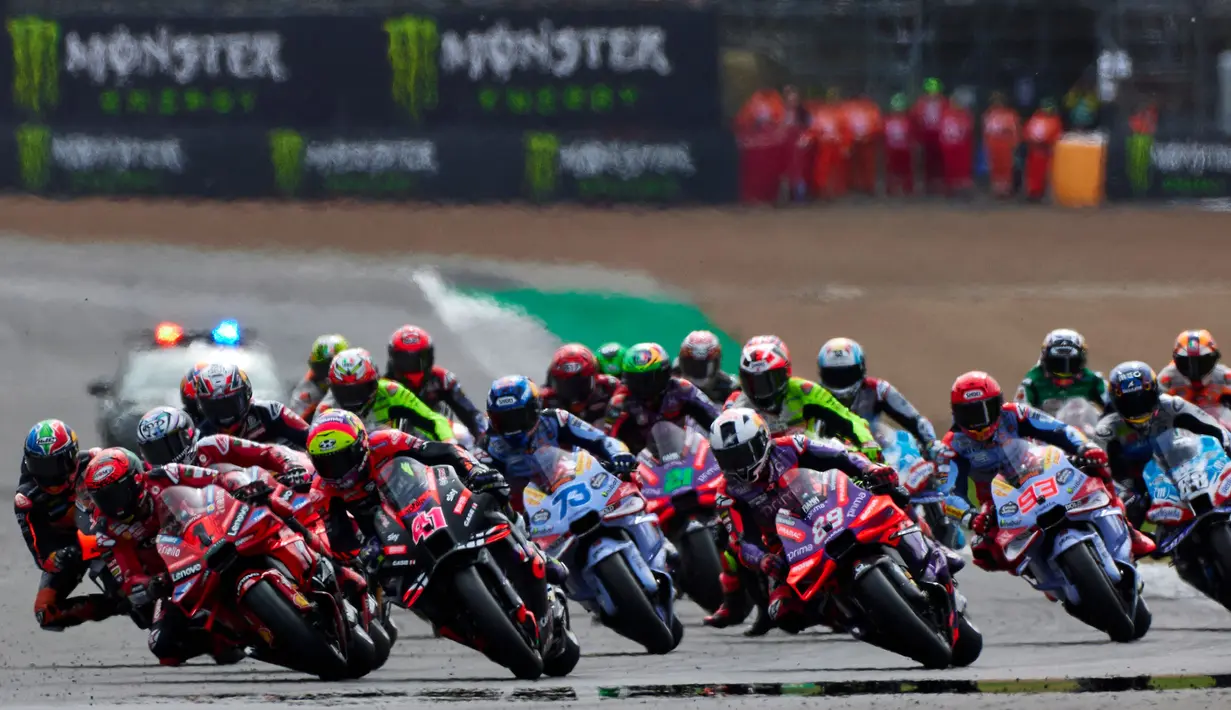 Balapan sprint MotoGP Grand Prix Inggris yang digelar di Sirkuit Silverstone pada Sabtu (3/8/2024) malam WIB langsung diwarnai crash di putaran pertama ketika balapan dimulai. Kala Marco Bezzecchi dan Franco Morbidelli terjatuh. (BENJAMIN CREMEL/AFP)