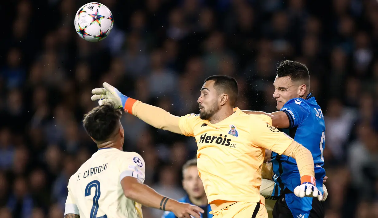 Kiper FC Porto, Diogo Costa (tengah) berusaha menghalau bola dari ancaman striker Club Brugge, Ferran Jutgla pada laga Grup B Liga Champions 2022/2023 di Jan Breydel Stadium, Bruges, Belgia (26/10/2022). Pada musim 2022/2023 meski gagal menjuarai Liga Portugal, Diogo Costa tampil ciamik dengan mencatat 16 kali nirbobol dari 33 laga. Dari jumlah laga yang sama, ia hanya kebobolan sebanyak 22 kali. (AFP/Kenzo Tribouillard)