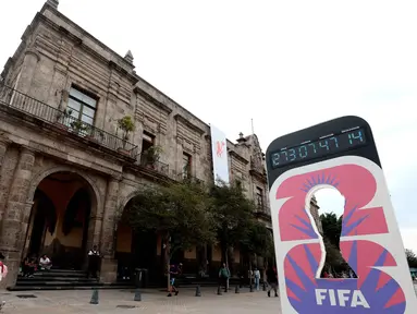 Seorang wanita berjalan melewati jam hitung mundur Piala Dunia 2026 di Guadalajara, Negara Bagian Jalisco, Meksiko pada 10 September 2025. (ULISES RUIZ/AFP)
