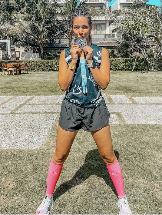 Nia Ramadhani pun memamerkan medali lari marathonnya. Ia tampil dengan atasan tanpa lengan dipadukan celana pendek hitam. Serta sepatu lari Nike dan kaos kaki panjang pinknya. [@ramadhaniabakrie]