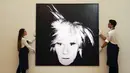 Staf memegang 'Self Portrait' karya Andy Warhol di Sotheby's di London, Inggris, 22 Juni 2022. Lukisan yang akan dilelang pada 29 Juni 2022 itu diperkirakan memiliki harga 12-18 juta pound. (AP Photo/Alberto Pezali)