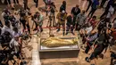 Para jurnalis mengambil gambar peti mati emas mumi Nedjemankh yang dipajang di Museum Nasional Peradaban Mesir, Kairo, Selasa (1/10/2019). Peti mati itu dikembalikan ke Mesir dari AS pekan lalu setelah ditetapkan sebagai barang antik yang dijarah. (Khaled DESOUKI/AFP)