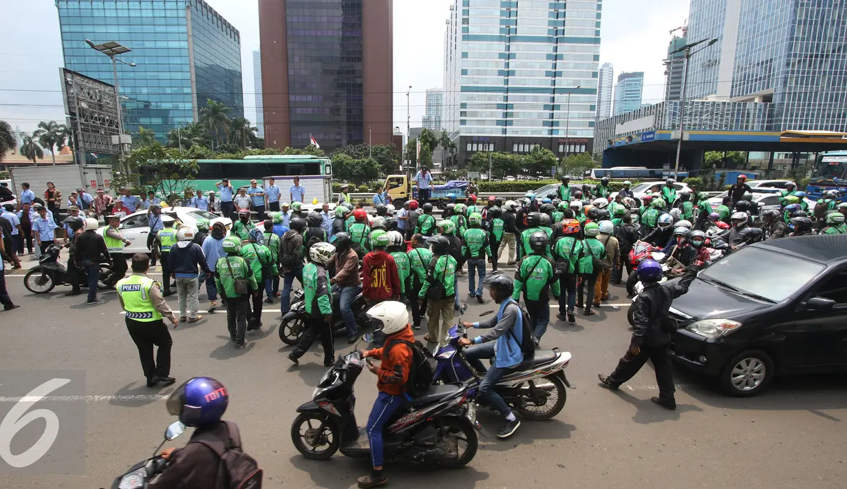 Ratusan pengendara Go-Jek terlibat kericuhan dengan sopir taksi di Jakarta, Selasa (22/3). Ratusan Go-Jek mendatangi para sopir taksi karena tersebar isu pemukulan terhadap beberapa pengendara Go-Jek oleh sopir taksi.  (Liputan6.com/Immanuel Antonius)