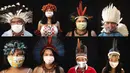 Kombinasi foto dari tanggal 27 Mei hingga 1 Juni 2020 menunjukkan orang-orang pribumi mengenakan masker dan pakaian tradisional suku mereka selama pandemi virus corona COVID-19 di Manaus, Brasil. (AP Photo/Felipe Dana)