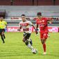 Pemain Persija Jakarta Dony Tri Pamungkas dikawal ketat pemain belakang Madura United Dodi Alekvan Djin dalam pekan ke-32 BRI Liga 1 2021/2022 di Stadion Kapten I Wayan Dipta, Kamis (17/3/2022). (Bola.com/Maheswara Putra)