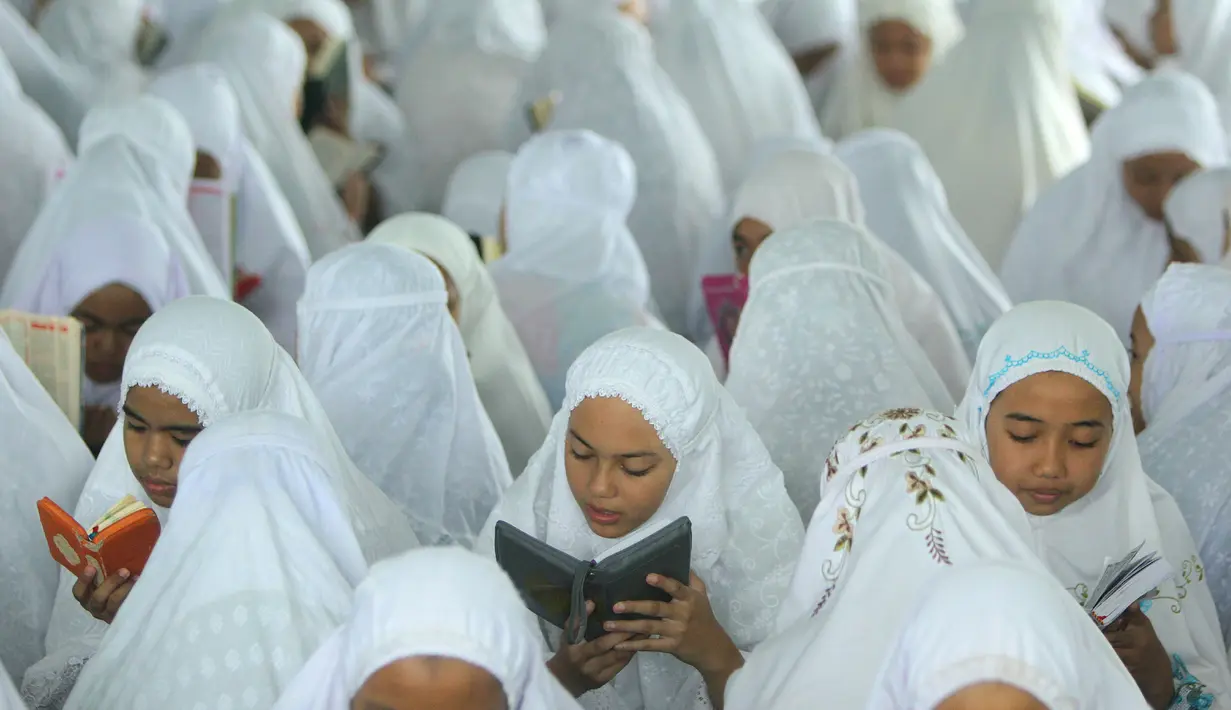 Puluhan santri membaca Al Quran saat tadarus massal awal Ramadhan 1440 H di Pesantren Ar-Raudhatul Hasanah, Medan, Sumatera Utara pada 6 Mei 2019. Tadarus yang diikuti sedikitnya 3.200 santri tersebut merupakan kegiatan rutin selama bulan Ramadan di pesantren tersebut. (RAHMAD SURYADI / AFP)