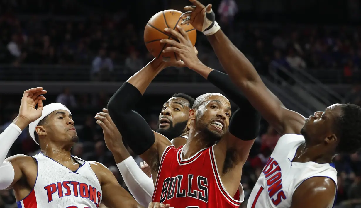 Ekspresi pemain Chicago Bulls, Taj Gibson (tengah) saat mendapat adangan dari para pemain Detroit Pistons pada laga NBA di Auburn Hills, (07/12/2016). (AP/Paul Sancya)
