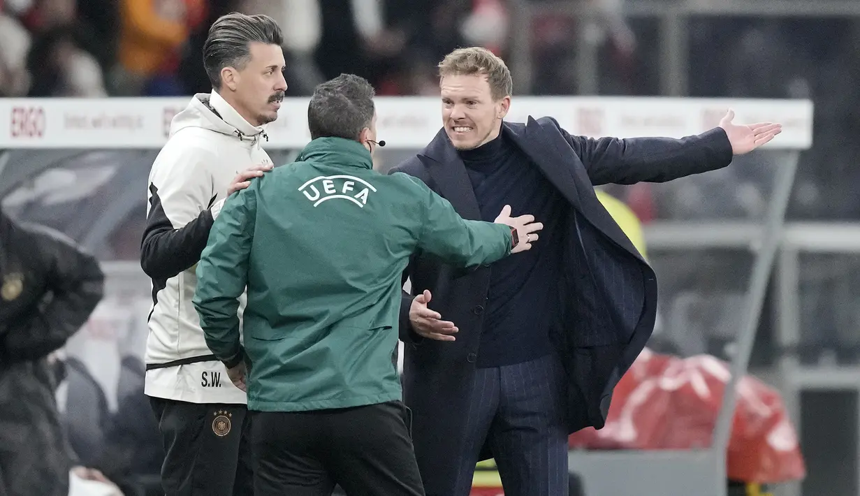 Pelatih Timnas Jerman, Julian Nagelsmann (kanan) melancarkan protes kepada ofisial keempat atas putusan wasit saat menghadapi Timnas Turki pada laga uji coba internasional di Olympiastadion, Berlin, Minggu (19/11/2023) dini hari WIB. (AP Photo/Markus Schreiber)