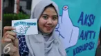 Pengunjung menunjukkan stiker saat Pameran Peringatan Hari Anti Korupsi oleh ICW, Jakarta, Jum’at (9/12). ICW memperingati Hari Anti Korupsi Dunia dengan Pameran instalasi anti korupsi, diskusi dan konser musik. (Liputan6.com/Gempur M Surya)