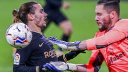 Penyerang Barcelona, Antoine Griezmann, berebut bola dengan kiper Cadiz, Jeremias Ledesma, pada laga Liga Spanyol di Stadion Ramon Carranza, Minggu (6/12/2020). Barcelona takluk dengan skor 1-2. (AP/Alvaro Rivero)