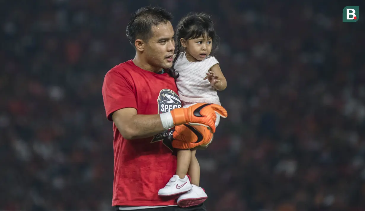 Kiper Persija Jakarta, Andritany Ardhiyasa, menggendong sang putri merayakan gelar juara Piala Presiden di SUGBK, Jakarta, Sabtu (17/2/2018). Persija menang 2-0 atas Bali United. (Bola.com/Vitalis Yogi Trisna)