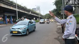 Petugas Dishub mengatur kendaraan yang melintasi Jalan TB Simatupang, Jakarta, Senin (12/12). Dinhubtrans Jaksel menyiagakan petugas di sejumlah titik rawan kemacetan untuk antisipasi penumpukan kendaraan saat arus balik. (Liputan6.com/Yoppy renato)