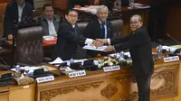 Fadli Zon (kiri) menerima hasil pembahasan tingkat 1 dari Ketua Komisi II Rambe Kamarulzaman (kanan) saat rapat paripurna DPR, Jakarta, Selasa (17/2/2015). Dalam rapat tersebut DPR mengesahkan revisi UU Pilkada dan UU Pemda. (Liputan6.com/Andrian M Tunay)