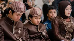 Kebaya yang dikenakan Putri Delina adalah model kutubaru berwarna cokelat tua, terbuat dari brokat dengan bordir bunga dan payet yang berkilauan. Warna cokelat tua yang dipilih juga memberikan nuansa hangat, selaras dengan tema busana keluarga. (Liputan6.com/IG/@putridelinaa)