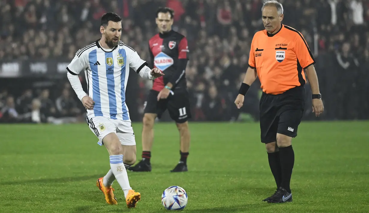 Lionel Messi (kiri) saat bertanding memakai seragam Timnas Argentina dalam acara pertandingan perpisahan Maxi Rodriguez sebagai pesepak bola profesional yang diselenggarakan di Marcelo Bielsa Stadium, Argentina, Minggu (25/6/2023). (AFP/Stringer)