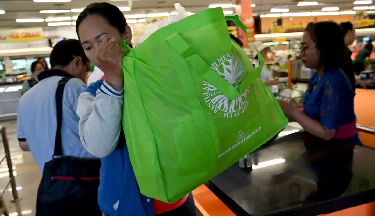 Seorang konsumen menggunakan tas belanja nonplastik untuk mengemas barang belanjaan di sebuah supermarket di Denpasar, 16 Juli 2019. Bali menerapkan pelarangan penggunaan plastik sekali pakai yang tertuang dalam Peraturan Gubernur (Pergub) Nomor 97 Tahun 2018. (SONNY TUMBELAKA/AFP)