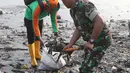 Petugas TNI memasukan sampah ke dalam karung saat mengikuti Gerebek Sampah di Pesisir Teluk Jakarta, Cilincing, Jakarta Utara, Minggu (15/4). (Liputan6.com/Arya Manggala)