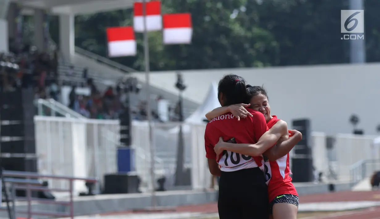 Pelari difable Indonesia, Nurhaida Insan (kanan) dipeluk rekannnya usai berlaga di kelas Womens 100m T36/37/38 Indonesia Para Games Invitational Tournament 2018 di Stadion Madya Senayan, Jakarta, Minggu (1/7). (Liputan6.com/Helmi Fithriansyah)