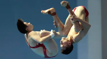 Aksi atlet loncat indah China, Lian Junjie dan Si Yajie saat tampil pada babak final platform sinkronisasi 10 meter campuran di Kejuaraan Renang Dunia, Gwangju, Korea Selatan, Sabtu (13/7/2019). (AP Photo/Lee Jin-man)