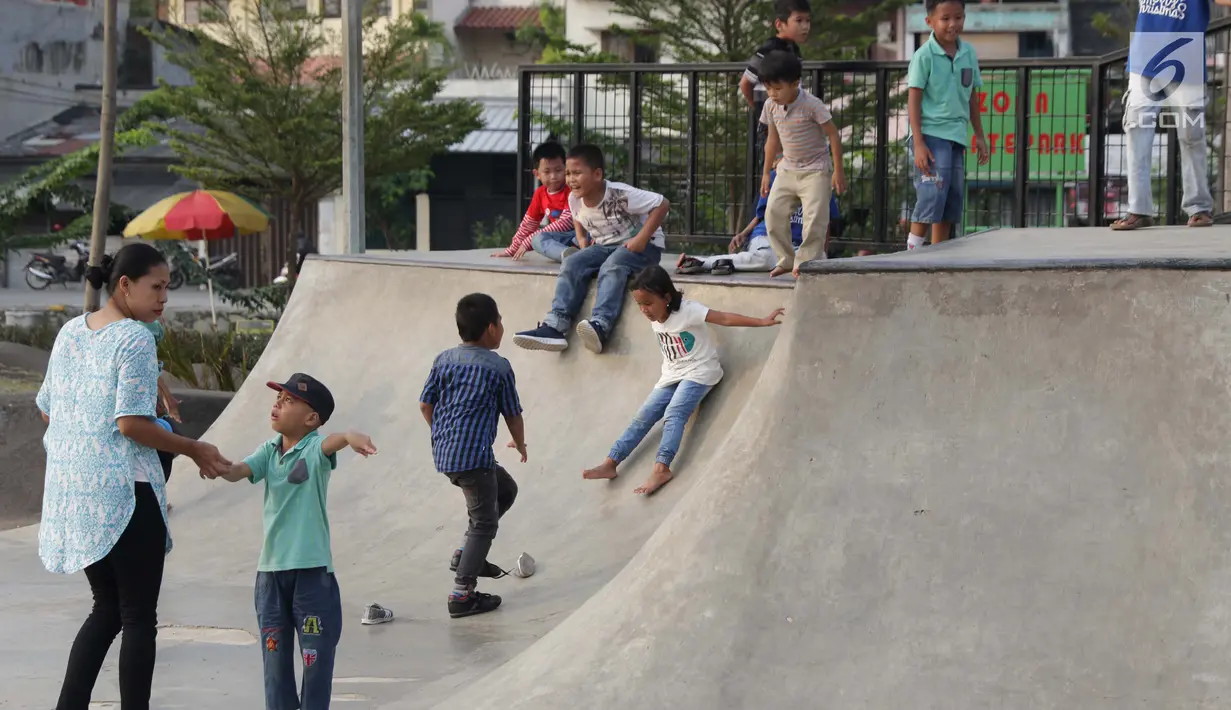 Beberapa orang anak bermain meluncur di area Skate Park RPTRA Kalijodo, Jakarta, Sabtu (15/6/2019). Menjelang sore hari, anak-anak berdatangan menghabiskan waktu dengan bermain di area RPTRA Kalijodo. (Liputan6.com/Helmi Fithriansyah)
