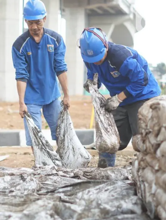 Petugas mengumpulkan sampah dan lumpur dari saluran gorong-gorong air di Jalan DI Panjaitan, Kebon Nanas, Jakarta, Jumat (6/12/2019). Hal tersebut dilakukan guna mengantisipasi tersumbatnya saluran air selama memasuki periode musim hujan. (Liputan6.com/Immanuel Antonius)