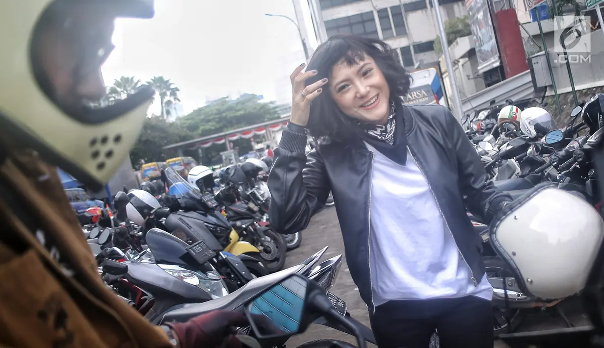 Poppy Sovia bersama suaminya, Ahmad Gussaoki saat menggunakan sepda motor di Jakarta, Senin (13/8). (Liputan6.com/ Faizal Fanani)