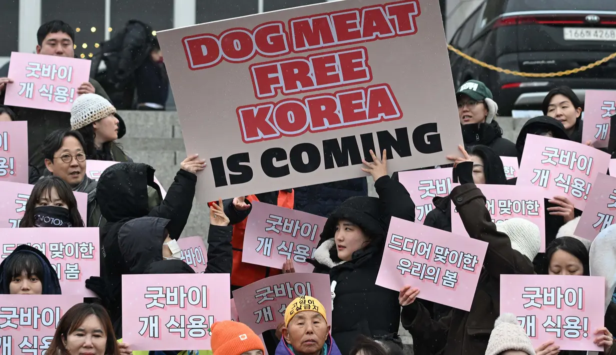Para aktivis hak-hak hewan memegang plakat bertuliskan "Selamat tinggal daging anjing!" di Majelis Nasional di Seoul pada tanggal 9 Januari 2024. (JUNG YEON-JE/AFP)