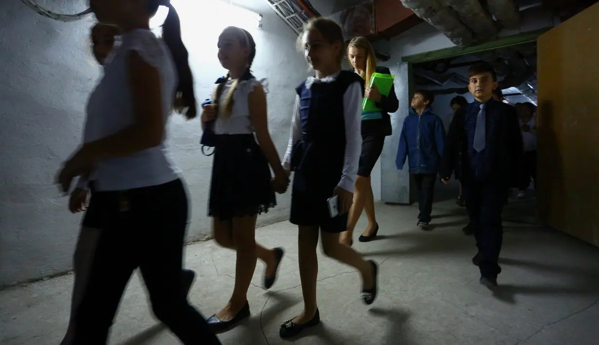 Anak-anak mengambil bagian dalam latihan keamanan di Sekolah Nomor 8, Desa Sartana wilayah timur Ukraina, 2 Oktober 2018. Di sekolah tersebut, para siswa menjalankan latihan menghadapi pengeboman sekali dalam sebulan. (Aleksey FILIPPOV/AFP)