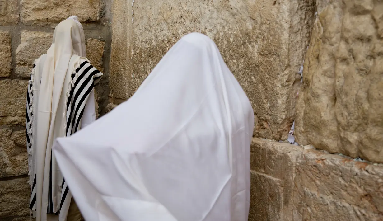 Umat Yahudi dari kasta imam berdoa menjelang Paskah di depan Tembok Barat, Yerusalem (13/4). Mereka melakukan upacara sebanyak tiga kali dalam setahun, yaitu Paskah, Shavuot dan Sukkot.  (AP Photo / Ariel Schalit) 