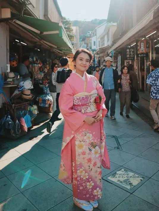 Michelle Ziudith mengenakan kimono pink dengan obi dan bawahan motif bunga sakura yang indah. Dengan gaya rambut ikatnya. [@michelleziu]