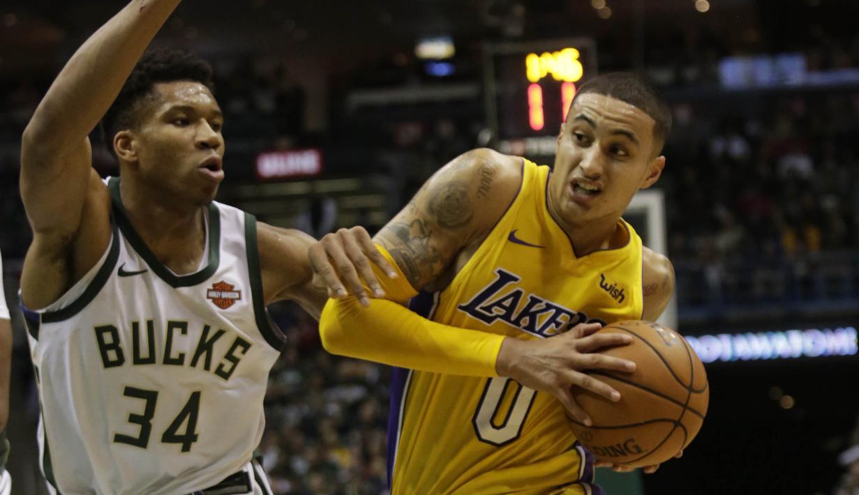 Pebasket Milwaukee Bucks, Giannis Antetokounmpo, berusaha meenghadang pebasket LA Lakers, Kyle Kuzma, pada laga NBA di Bradley Center, Minggu (12/11/2017). Bucks menang 98-90 atas LA Lakers. (AP/Darren Hauck)