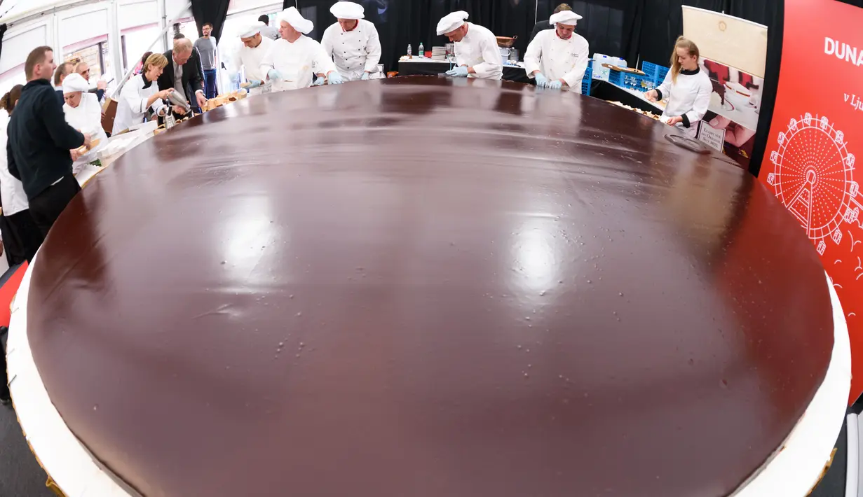 Para koki menyelesaikan pembuatan kue cokelat atau dikenal sebagai Sacher Torte di Ljubljana, Slovenia, Rabu (21/9). Kue cokelat dengan diameter 3,5 meter ini diklaim menjadi Sacher Torte terbesar di dunia. (AFP PHOTO/Jure MAKOVEC)