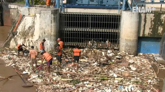 Banjir yang melanda Jakarta menyisakan sampah, pasukan oranye berjibaku membersihkan sampah meskipun kondisi aliran sungai masih deras