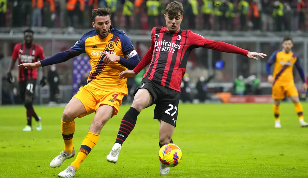 Pemain AS Roma Bryan Cristante (kiri) berebut bola dengan pemain AC Milan Daniel Maldini pada pertandingan sepak bola Serie A Liga Italia di Stadion San Siro, Milan, Italia, 6 Januari 2022. AC Milan menang 3-1. (AP Photo/Antonio Calanni)