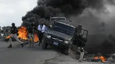 Polisi meninggalkan kendaraan mereka saat demonstrasi yang berubah menjadi kekerasan di Cap-Haitien, Haiti, Kamis (22/7/2021). Demonstrasi menuntut keadilan atas pembunuhan Presiden Haiti Jovenel Moise terus berlanjut dan menimbulkan kerusuhan. (AP Photo/Matias Delacroix)