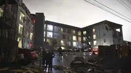 Puing-puing tersebar di tempat parkir gedung apartemen yang rusak setelah tornado menghantam Nashville, Selasa, (3/3/2020). Pihak berwenang meminta kepada warga untuk tetap tinggal di dalam rumah. (Courtney Pedroza / The Tennessean via AP)