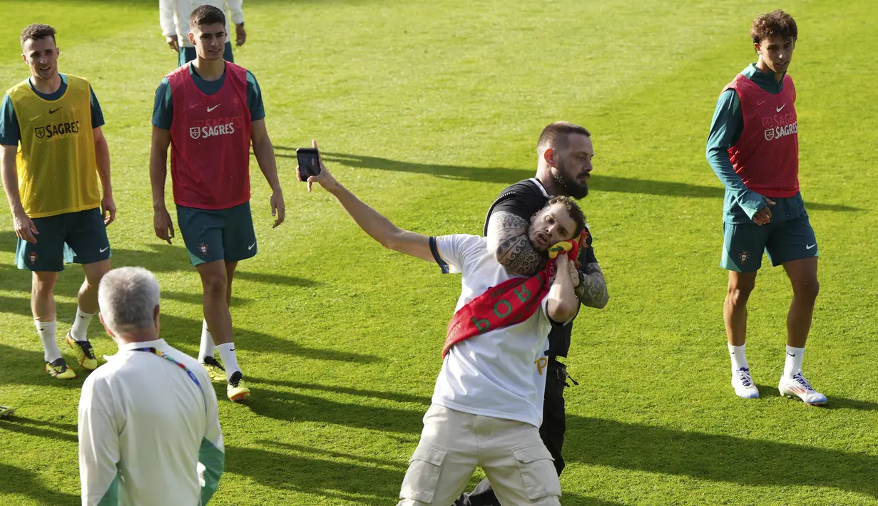 Sejumlah fans Ronald menyerbu masuk ke lapangan dan membuat sejumlah petugas keamanan langsung bertindak menghentikan mereka. (AP Photo/Hassan Ammar)