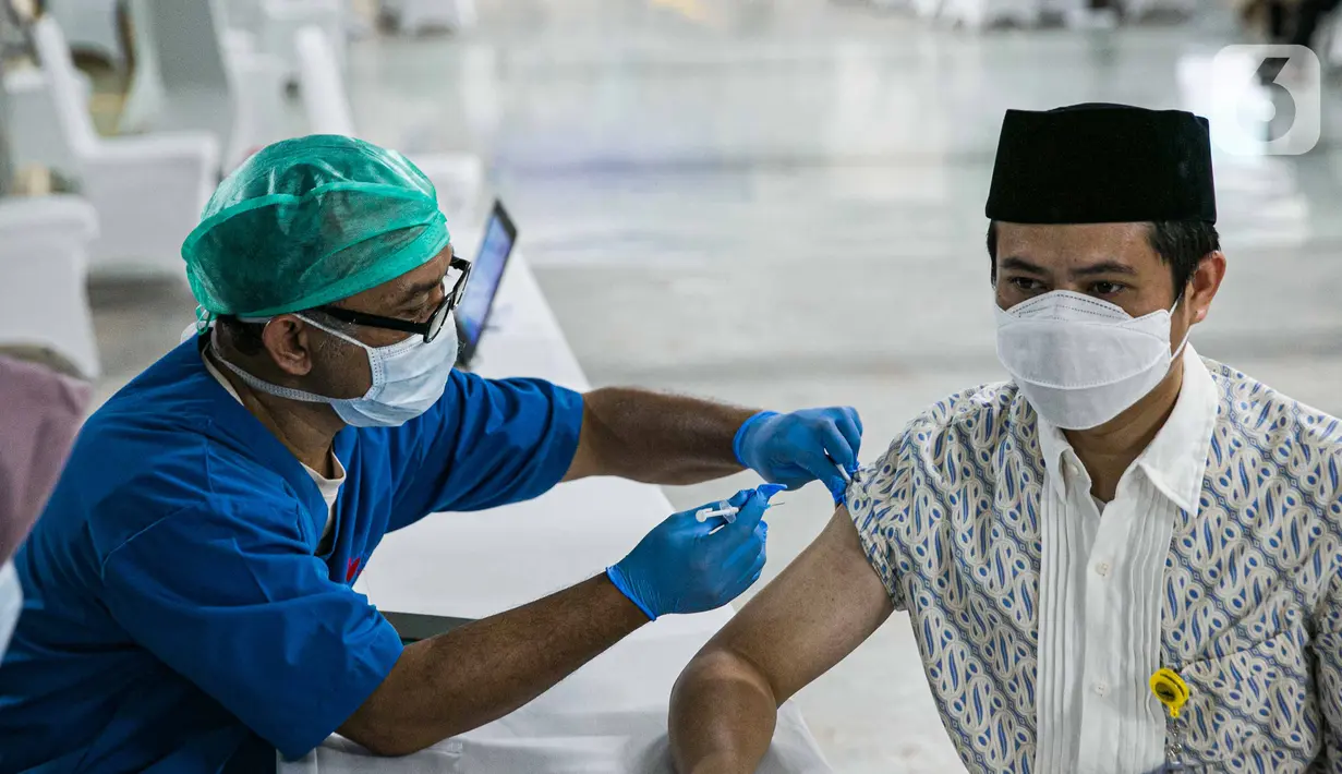 Petugas kesehatan menyuntikan vaksin COVID-19 kepada seorang pemuka agama di Mesjid Istiqlal, Jakarta, Selasa (23/2/2021). Para pemuka agama itu berasal dari seluruh wilayah di Jakarta. vaksinasi akan berlangsung selama dua hari. (Liputan6.com/Faizal Fanani)