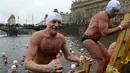 Orang-orang keluar dari sungai Vltava setelah mengikuti kompetisi berenang Natal tahunan, di ibu kota Republik ceko, Praha, Rabu (26/12). Dalam menyemarakkan Natal, mereka mengikuti lomba renang di sungai bersuhu dingin. (Michal CIZEK / AFP)