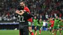 Kiper Portugal, Diogo Costa (kiri) dan Bruno Fernandes merayakan kemenangan atas Slovenia pada babak adu penalti saat babak 16 besar Euro 2024 di Frankfurt Arena, Frankfurt, Jerman, Senin (02/07/2024) WIB. (AFP/Javier Soriano)