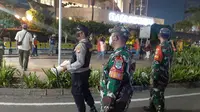 Personel TNI Polri mengingatkan masyarakat untuk mengosongkan kawasan Bundaran Hotel Indonesia, Jakarta Pusat, jelang tahun baru 2022. (Liputan6.com/Ady Anugrahadi)