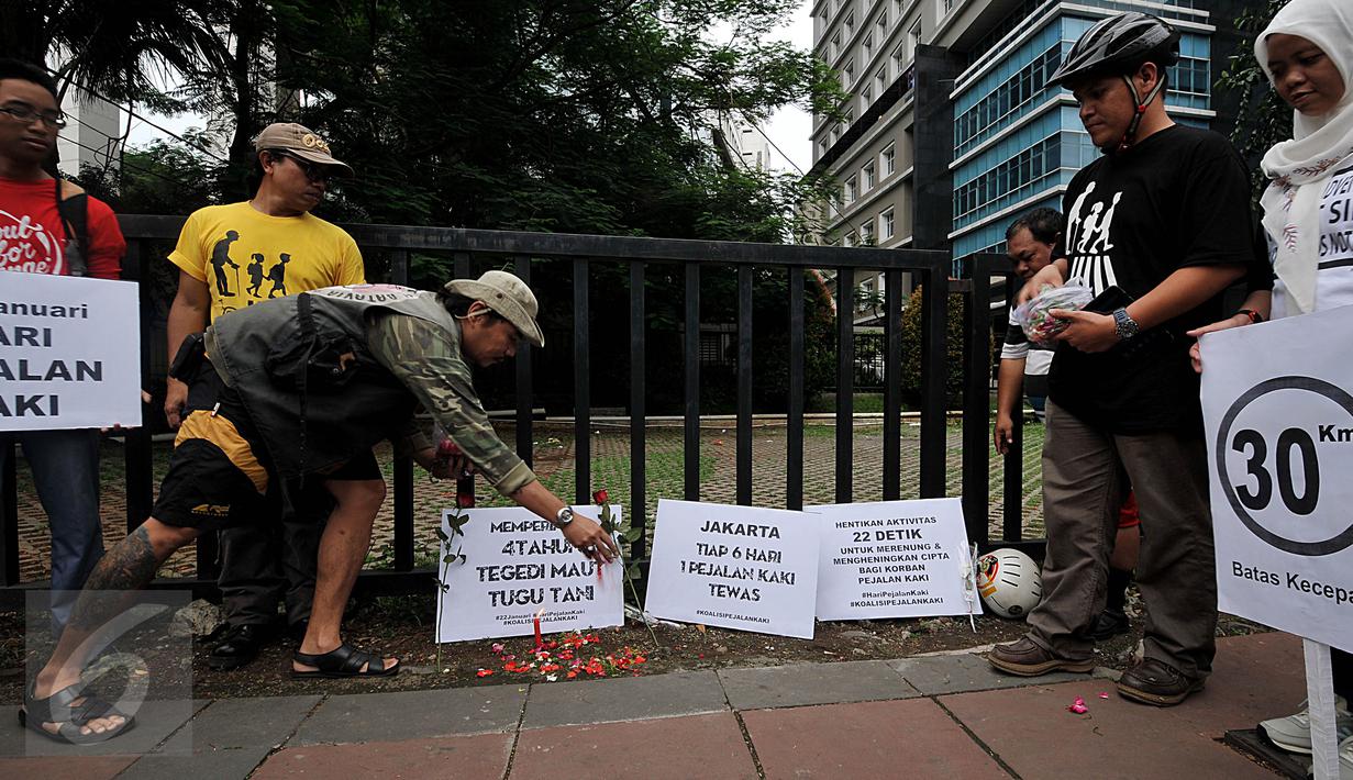 Massa yang tergabung dalam Koalisi Pejalan Kaki melakukan Aksi Doa dan Tabur Bunga di Halte Tugu Tani, Jakarta, Jumat (22/1). Aksi ini dalam rangka memperingati 4 tahun tragedi kecelakaan Tugu Tani yang menewaskan 12 orang. (Liputan6.com/Johan Tallo)