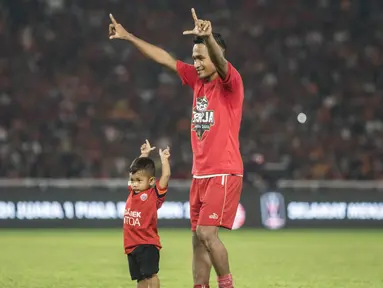 Gelandang Persija Jakarta, Ramdani Lestaluhu, mengajak sang anak menyapa suporter merayakan gelar juara Piala Presiden di SUGBK, Jakarta, Sabtu (17/2/2018). Persija menang 2-0 atas Bali United. (Bola.com/Vitalis Yogi Trisna)