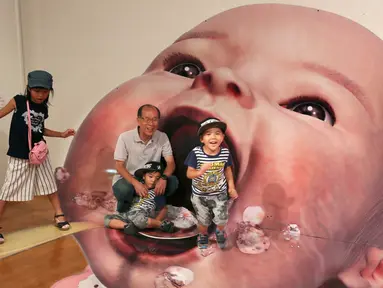Pengunjung berpose dengan gambar 3D seorang bayi di pameran seni trik 3D karya seniman Jepang Masashi Hattori di Kawasaki, dekat Tokyo, Sabtu, (5/8). (AP Photo / Koji Sasahara)